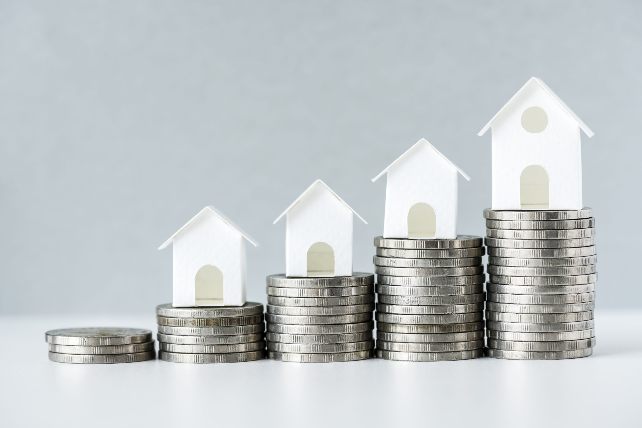 stacks of money with houses on top